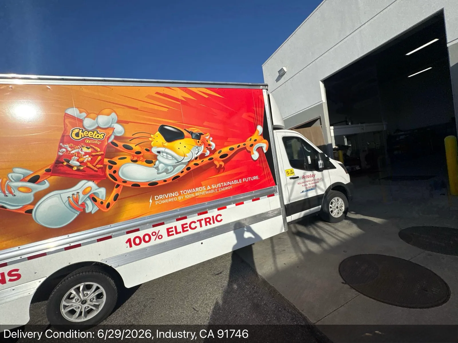 Side view of the wrapped electric box truck at delivery showing 100 percent electric lettering
