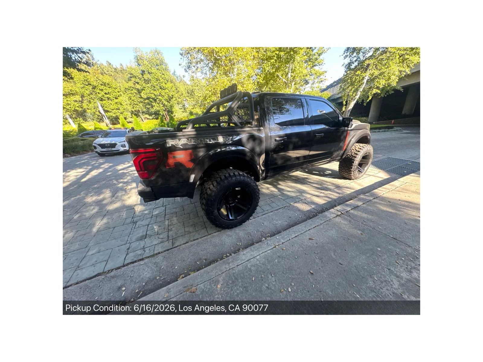 Lifted Ford F-150 Raptor R with bed chase rack and 37-inch tires at pickup-condition inspection in Los Angeles, California