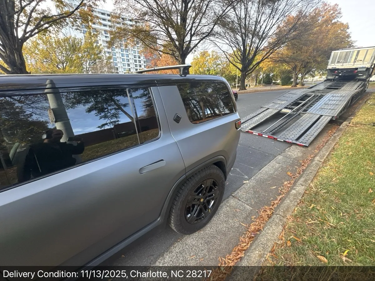 Rivian R1T being unloaded next to an open auto carrier ramp in Charlotte, NC