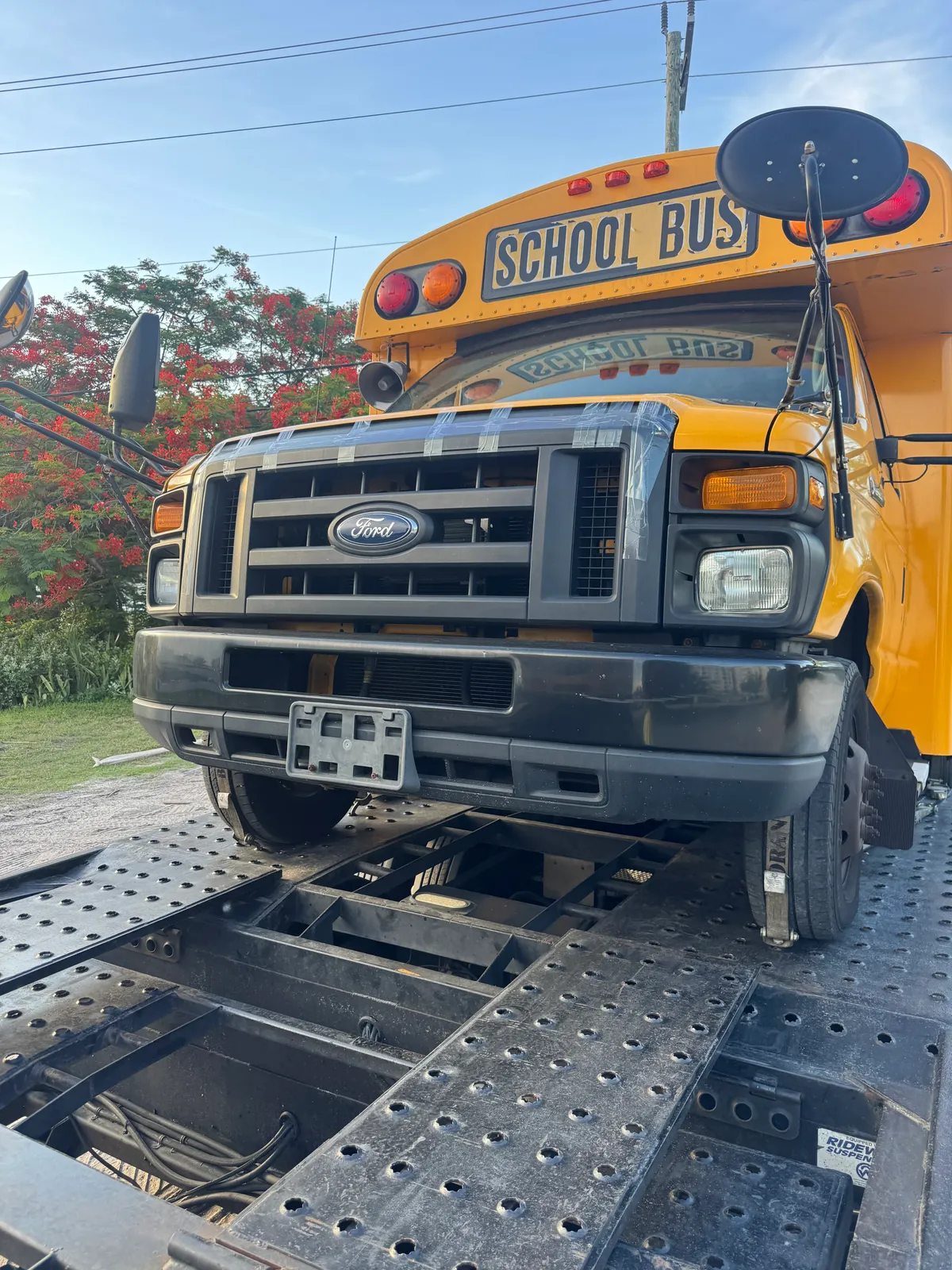School bus loaded and secured on a carrier trailer deck, front view